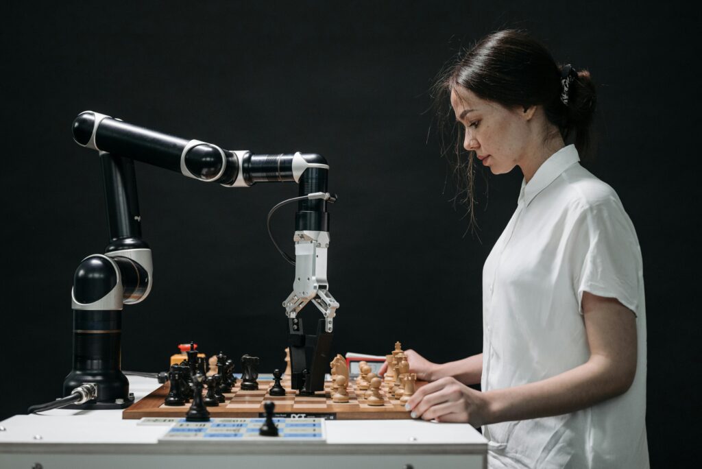 A robot and woman engage in chess, showcasing technology and strategic thinking.